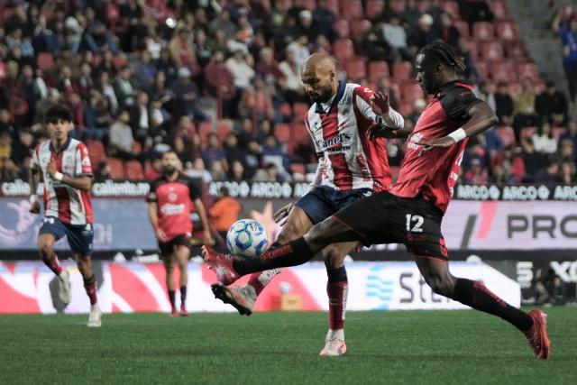 San Luis' Brazilian forward #09 Joao Pedro (L) and Tijuana's Ecuadorian defender #12 Jackson Porozo (R) fight for the ball during the Liga MX Clausura football match between Tijuana and Atletico de San Luis at the Caliente Stadium in Tijuana, Baja California, Mexico on January 17, 2026. (Photo by Guillermo ARIAS / AFP)
