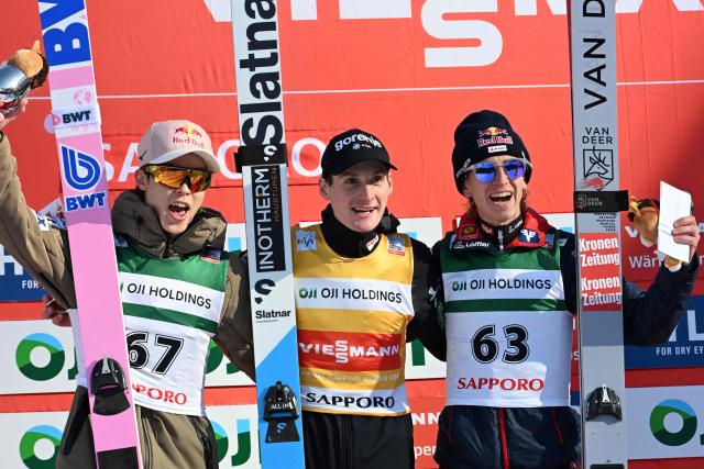 Winner Slovenia's Domen Prevc (C), second-placed Japan's Ryoyu Kobayashi (L) and third-placed Austria's Daniel Tschofenig (R) pose on the podium for the individual Large Hill HS137 competition on the third day of men's FIS Ski Jumping World Cup competition in Sapporo on January 18, 2026. (Photo by Toshifumi KITAMURA / AFP)