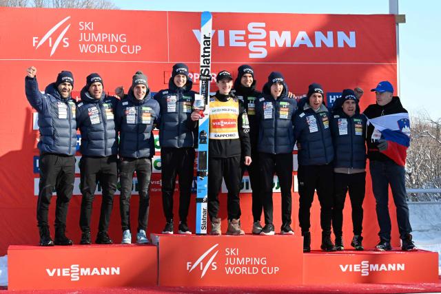 Winner Slovenia's Domen Prevc (C) and his team pose on the podium for the individual Large Hill HS137 competition on the third day of men's FIS Ski Jumping World Cup competition in Sapporo on January 18, 2026. (Photo by Toshifumi KITAMURA / AFP)