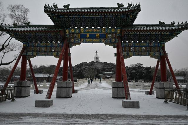 People visit the Beihai Park amid snowfall in Beijing on January 18, 2026. (Photo by ADEK BERRY / AFP)