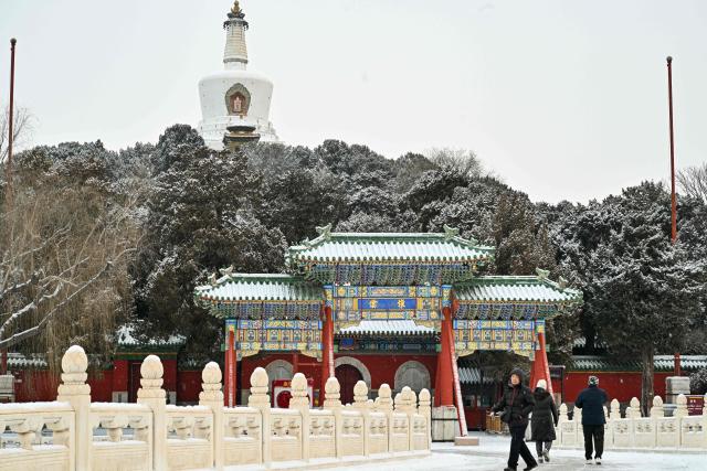 People visit the Beihai Park amid snowfall in Beijing on January 18, 2026. (Photo by ADEK BERRY / AFP)