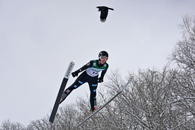 Germany's Ben Bayer takes his first jump as a crow flies past during the individual Large Hill HS137 competition on the third day of the men's FIS Ski Jumping World Cup competition in Sapporo on January 18, 2026. (Photo by Toshifumi KITAMURA / AFP)