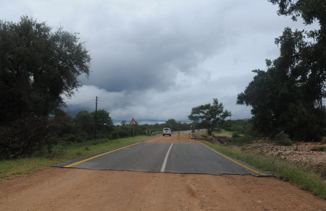 A general view of a damaged road on the way from Giyani to Mbaula on January 17, 2026 following heavy rains over much of the Limpopo Province, South Africa. Heavy rains have drenched the northeast of the country since late last year, claiming at least 30 lives. (Photo by LUCAS LEDWABA / AFP)