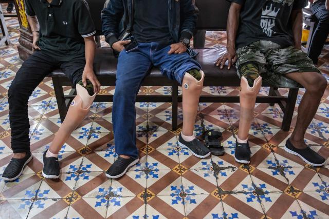 People wait to receive prosthetic legs, distributed for free to people with physical disabilities as part of a social service event by a Chinese foundation, at the Boen Bio Temple in Surabaya on January 18, 2026. (Photo by Juni KRISWANTO / AFP)