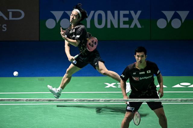 Japan’s Hiroki Midorikawa (L) and Kyohei Yamashita (R) play a return against China's Liang Wei Keng and Wang Chang during their men’s doubles final match at the India Open 2026 badminton tournament in New Delhi on January 18, 2026. (Photo by Sajjad HUSSAIN / AFP)