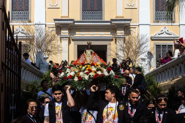 Members of the congregation hold a litter with Santo Niño (child Jesus) during the Sinulog Festival in Macau on January 18, 2026. (Photo by Eduardo Leal / AFP)