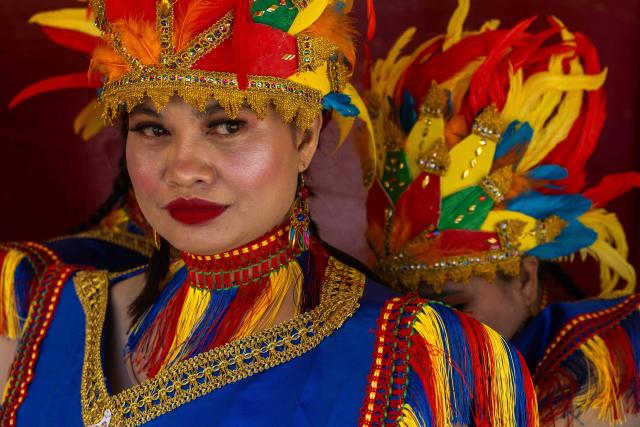 TOPSHOT - A member of The Heart of Filipino Services (THOFS) gets some help with her costume before the performance at the Sinulog Festival, which honours the Santo Niño (child Jesus), in Macau on January 18, 2026. (Photo by Eduardo Leal / AFP)