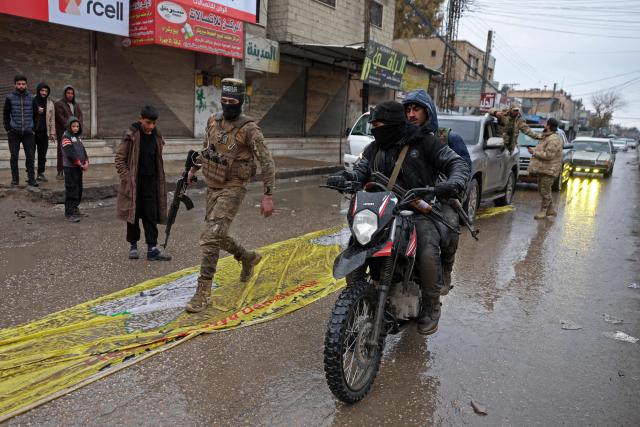 Syrian government troops patrol through the streets of Tabqa, in Raqa province, on the southwestern banks of the Euphrates on January 18, 2026. Kurdish-led forces withdrew on January 18 from Syria's largest oil field, a conflict monitor said, as government troops extended their grip over swathes of territory in the country's north and east. Government troops drove Kurdish forces from two Aleppo neighbourhoods following clashes last week, and on January 17 announced they had captured an area east of the city, as well as Tabqa. (Photo by OMAR HAJ KADOUR / AFP)