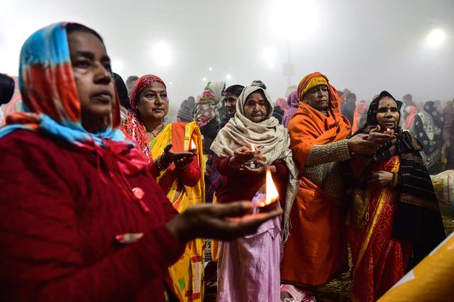 Hindu devotees offer prayers along the banks of Sangam, the confluence of Ganges, Yamuna and mythical Saraswati rivers, on the occasion of 'Mauni Amavasya' observed during the Magh Mela festival in Prayagraj on January 18, 2026. (Photo by AFP)
