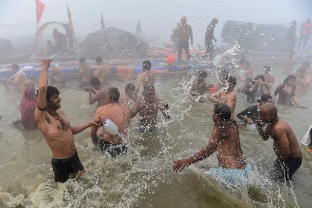 Hindu devotees offer prayers and take a holy dip in Sangam, the confluence of Ganges, Yamuna and mythical Saraswati rivers, on the occasion of 'Mauni Amavasya' observed during the Magh Mela festival in Prayagraj on January 18, 2026. (Photo by AFP)