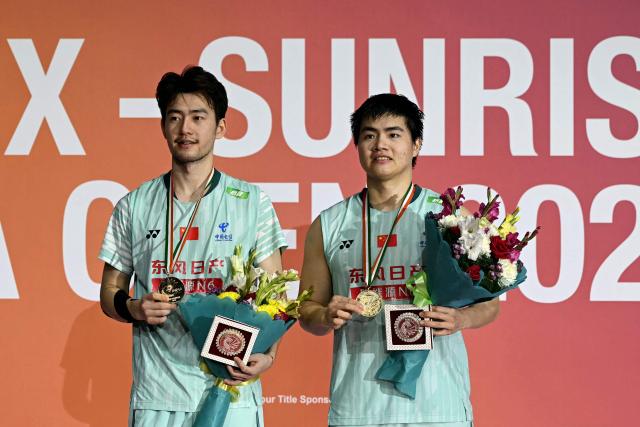 Gold medallists China's Liang Wei Keng (R) and Wang Chang pose during the awards ceremony for the men's doubles final match against Japan’s Hiroki Midorikawa and Kyohei Yamashita at the India Open 2026 badminton tournament in New Delhi on January 18, 2026. (Photo by Sajjad HUSSAIN / AFP)