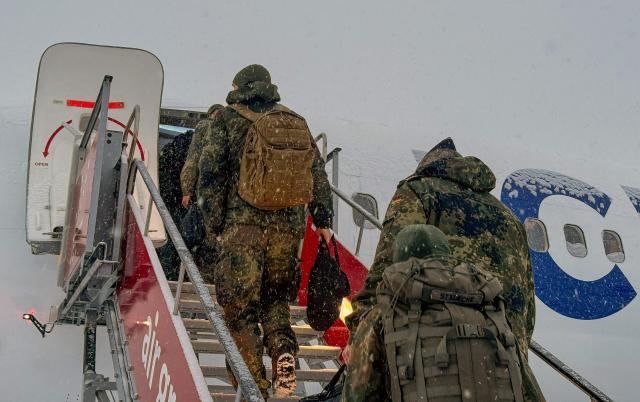 Military personnel from the German armed Forces Bundeswehr board Icelandair flight  leaving Nuuk airport for Reykjavik on January 18, 2026 in Nuuk, Greenland. US President Donald Trump escalated his quest to acquire Greenland, threatening multiple European nations with tariffs of up to 25 percent until his purchase of the Danish territory is achieved. Trump's threats came as thousands of people protested in the capital of Greenland against his wish to acquire the mineral-rich island at the gateway to the Arctic. (Photo by Alessandro RAMPAZZO / AFP)