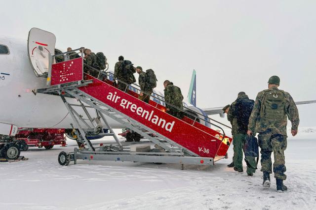 Military personnel from the German armed Forces Bundeswehr board Icelandair flight  leaving Nuuk airport for Reykjavik on January 18, 2026 in Nuuk, Greenland. US President Donald Trump escalated his quest to acquire Greenland, threatening multiple European nations with tariffs of up to 25 percent until his purchase of the Danish territory is achieved. Trump's threats came as thousands of people protested in the capital of Greenland against his wish to acquire the mineral-rich island at the gateway to the Arctic. (Photo by Alessandro RAMPAZZO / AFP)
