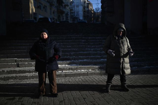 Practioners of the Falun Gong religious movement, also known as Falun Dafa, meditate on a street in Kyiv on January 18, 2026, amid the Russian invasion of Ukraine. (Photo by Sergei GAPON / AFP)