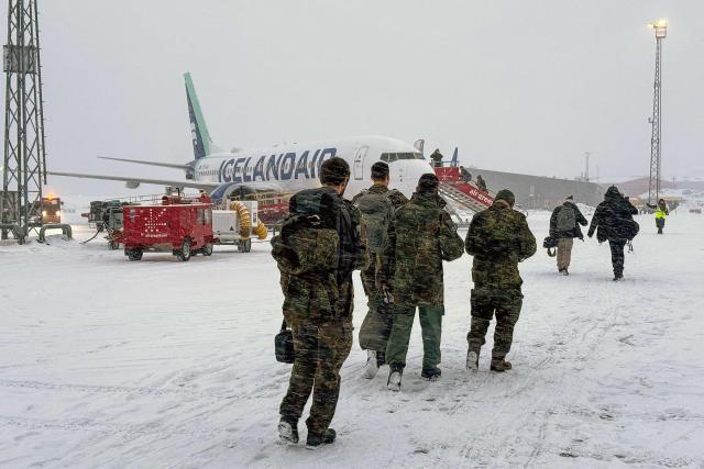 Military personnel from the German armed Forces Bundeswehr board Icelandair flight  leaving Nuuk airport for Reykjavik on January 18, 2026 in Nuuk, Greenland. US President Donald Trump escalated his quest to acquire Greenland, threatening multiple European nations with tariffs of up to 25 percent until his purchase of the Danish territory is achieved. Trump's threats came as thousands of people protested in the capital of Greenland against his wish to acquire the mineral-rich island at the gateway to the Arctic. (Photo by Alessandro RAMPAZZO / AFP)