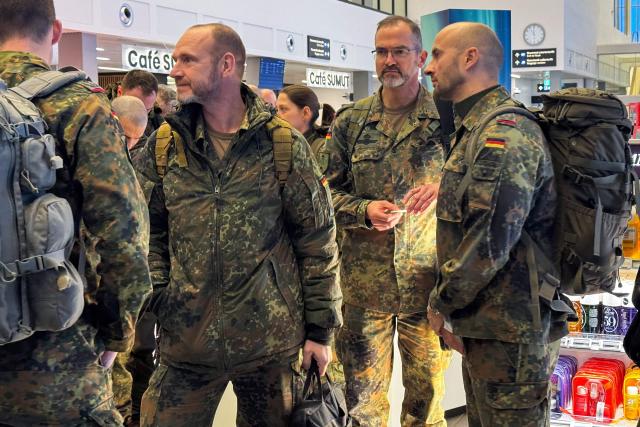 Military personnel from the German armed Forces Bundeswehr wait to board the Icelandair flight leaving Nuuk airport for Reykjavik on January 18, 2026 in Nuuk, Greenland. US President Donald Trump escalated his quest to acquire Greenland, threatening multiple European nations with tariffs of up to 25 percent until his purchase of the Danish territory is achieved. Trump's threats came as thousands of people protested in the capital of Greenland against his wish to acquire the mineral-rich island at the gateway to the Arctic. (Photo by Alessandro RAMPAZZO / AFP)