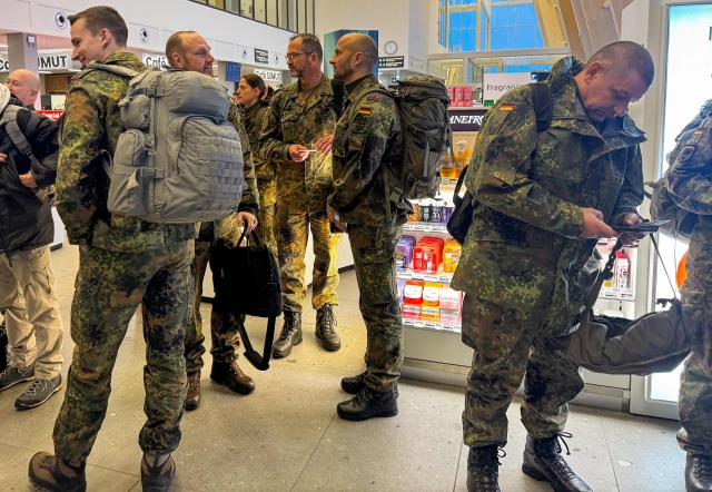 Military personnel from the German armed Forces Bundeswehr wait to board the Icelandair flight leaving Nuuk airport for Reykjavik on January 18, 2026 in Nuuk, Greenland. US President Donald Trump escalated his quest to acquire Greenland, threatening multiple European nations with tariffs of up to 25 percent until his purchase of the Danish territory is achieved. Trump's threats came as thousands of people protested in the capital of Greenland against his wish to acquire the mineral-rich island at the gateway to the Arctic. (Photo by Alessandro RAMPAZZO / AFP)