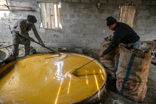 Workers process freshly harvested sugarcane into jaggery on the outskirts of Peshawar on January 18, 2026. (Photo by Abdul MAJEED / AFP)