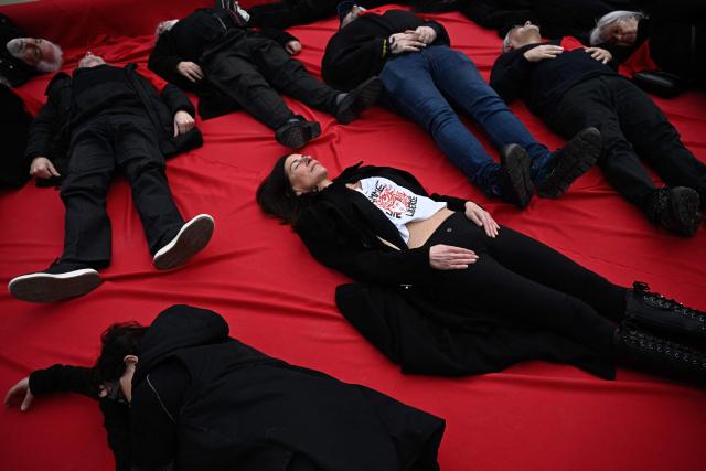 Demonstrators take part in a die-in protest in support of the Iranian People in front of the Fontaine des Innocents on Place Joachim du Bellay in Paris on January 18, 2026. (Photo by JULIEN DE ROSA / AFP)