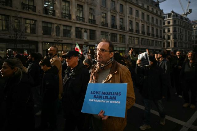 Protesters hold placards as they take part in a march to Downing Street against Iran's crackdown on protesters, in London on January 18, 2026. (Photo by JUSTIN TALLIS / AFP)