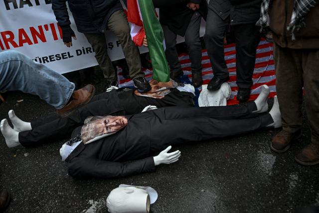 Protesters stomp on figures of US President Donald Trump and Israeli Prime Minister Benjamin Netanyahu as they shout slogans against the US and Israel during a pro-Iranian regime demonstration in front of the Iranian consulate in Istanbul, on January 18, 2026. Iranian authorities have said they are considering "gradually" restoring internet access after imposing an unprecedented communications shutdown 10 days ago, which rights groups say masked a violent protest crackdown that killed thousands. Demonstrations sparked in late December by anger over economic hardship exploded into protests widely seen as the biggest challenge to the Iranian leadership in years. (Photo by Ozan KOSE / AFP)