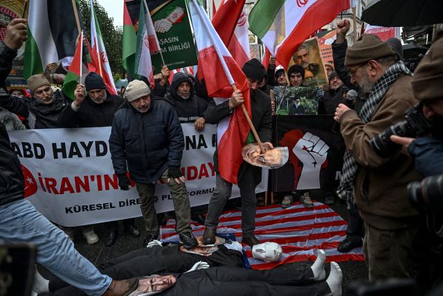Protesters stomp on figures of US President Donald Trump and Israeli Prime Minister Benjamin Netanyahu as they shout slogans against the US and Israel during a pro-Iranian regime demonstration in front of the Iranian consulate in Istanbul, on January 18, 2026. Iranian authorities have said they are considering "gradually" restoring internet access after imposing an unprecedented communications shutdown 10 days ago, which rights groups say masked a violent protest crackdown that killed thousands. Demonstrations sparked in late December by anger over economic hardship exploded into protests widely seen as the biggest challenge to the Iranian leadership in years. (Photo by Ozan KOSE / AFP)