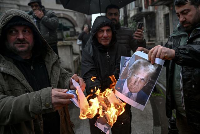 Protesters set afire portraits of US President Donald Trump and Israeli Prime Minister Benjamin Netanyahu during a pro-Iranian regime demonstration in front of the Iranian consulate in Istanbul, on January 18, 2026. Iranian authorities have said they are considering "gradually" restoring internet access after imposing an unprecedented communications shutdown 10 days ago, which rights groups say masked a violent protest crackdown that killed thousands. Demonstrations sparked in late December by anger over economic hardship exploded into protests widely seen as the biggest challenge to the Iranian leadership in years. (Photo by Ozan KOSE / AFP)