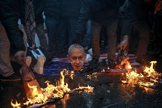 Protesters set afire protraits of US President Donald Trump and Israeli Prime Minister Benjamin Netanyahu during a pro-Iranian regime demonstration in front of the Iranian consulate in Istanbul, on January 18, 2026. Iranian authorities have said they are considering "gradually" restoring internet access after imposing an unprecedented communications shutdown 10 days ago, which rights groups say masked a violent protest crackdown that killed thousands. Demonstrations sparked in late December by anger over economic hardship exploded into protests widely seen as the biggest challenge to the Iranian leadership in years. (Photo by Ozan KOSE / AFP)