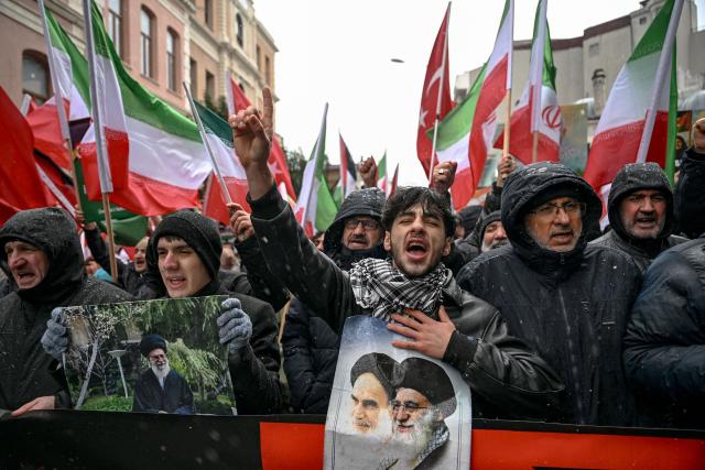 Protesters hold pictures of Iran's Supreme Leader Ayatollah Ali Khamenei and late former supreme leader Ruhollah Khomeini during a pro-Iranian regime demonstration in front of the Iranian consulate in Istanbul, on January 18, 2026. Iranian authorities have said they are considering "gradually" restoring internet access after imposing an unprecedented communications shutdown 10 days ago, which rights groups say masked a violent protest crackdown that killed thousands. Demonstrations sparked in late December by anger over economic hardship exploded into protests widely seen as the biggest challenge to the Iranian leadership in years. (Photo by Ozan KOSE / AFP)