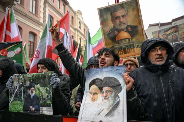 Protesters hold pictures of Iran's Supreme Leader Ayatollah Ali Khamenei, late former supreme leader Ruhollah Khomeini and slain commander of Iran's Revolutionary Guards Qasem Soleimani during a pro-Iranian regime demonstration in front of the Iranian consulate in Istanbul, on January 18, 2026. Iranian authorities have said they are considering "gradually" restoring internet access after imposing an unprecedented communications shutdown 10 days ago, which rights groups say masked a violent protest crackdown that killed thousands. Demonstrations sparked in late December by anger over economic hardship exploded into protests widely seen as the biggest challenge to the Iranian leadership in years. (Photo by Ozan KOSE / AFP)