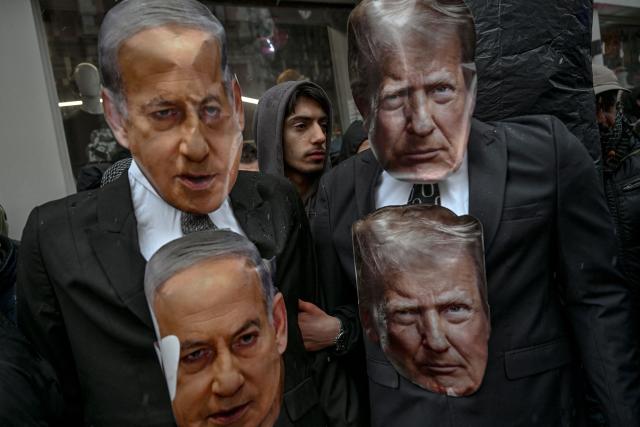 A protester stands next to effigies of the US President, Donald Trump, and the Israeli Prime Minister, Benjamin Netanyahu, shouting slogans against the US and Israel during a pro-Iranian regime demonstration outside the Iranian consulate in Istanbul, on January 18, 2026. Iranian authorities have said they are considering "gradually" restoring internet access after imposing an unprecedented communications shutdown 10 days ago, which rights groups say masked a violent protest crackdown that killed thousands. Demonstrations sparked in late December by anger over economic hardship exploded into protests widely seen as the biggest challenge to the Iranian leadership in years. (Photo by Ozan KOSE / AFP)
