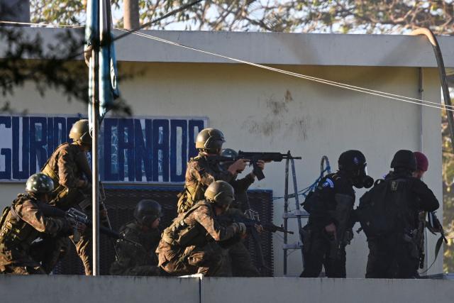 Soldiers take position during a riot at the Renovacion I maximum-security prison in Escuintla, Guatemala, on January 18, 2026. Gang groups held more than 40 guards in several prisons in Guatemala on January 17 as they rioted in protest over the transfer of their leaders to a maximum-security facility, authorities said. (Photo by JOHAN ORDONEZ / AFP)
