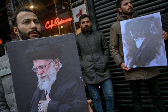 Protesters hold pictures of Iran's Supreme Leader, Ayatollah Ali Khamenei, and the late founder of the Islamic Republic of Iran, Ayatollah Ruhollah Khomeini, during a pro-Iranian regime demonstration in front of the Iranian consulate in Istanbul, on January 18, 2026. Iranian authorities have said they are considering "gradually" restoring internet access after imposing an unprecedented communications shutdown 10 days ago, which rights groups say masked a violent protest crackdown that killed thousands. Demonstrations sparked in late December by anger over economic hardship exploded into protests widely seen as the biggest challenge to the Iranian leadership in years. (Photo by Ozan KOSE / AFP)