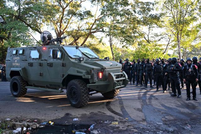 An army armored vehicle takes up position during a riot at the Renovacion I maximum-security prison in Escuintla, Guatemala, on January 18, 2026. Gang groups held more than 40 guards in several prisons in Guatemala on January 17 as they rioted in protest over the transfer of their leaders to a maximum-security facility, authorities said. (Photo by JOHAN ORDONEZ / AFP)