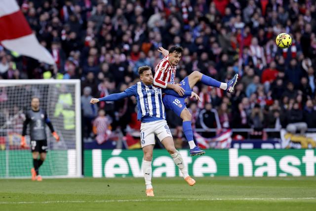 Alaves' Spanish forward #11 Toni Martinez and Atletico Madrid's Spanish defender #18 Marc Pubill jump for the ball during the Spanish league football match between Club Atletico de Madrid and Deportivo Alaves at Metropolitano Stadium in Madrid on January 18, 2026. (Photo by Oscar DEL POZO / AFP)