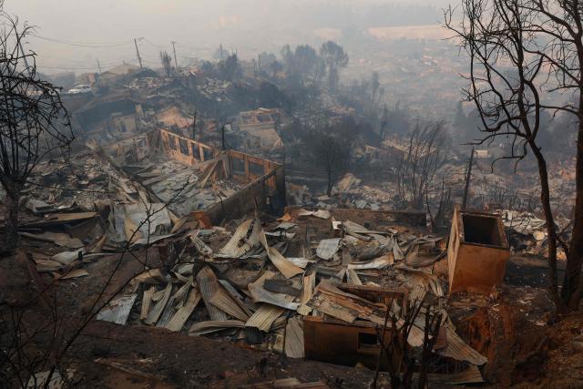 View of the charred remains of destroyed homes after a wildfire in Concepcion, Chile, on January 18, 2026. Wildfires raging in southern Chile have killed at least 15 people and forced more than 50,000 to evacuate, the government said. (Photo by Raul BRAVO / AFP)