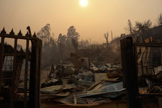 View of the charred remains of a destroyed home after a wildfire in Concepcion, Chile, on January 18, 2026. Wildfires raging in southern Chile have killed at least 15 people and forced more than 50,000 to evacuate, the government said. (Photo by Raul BRAVO / AFP)