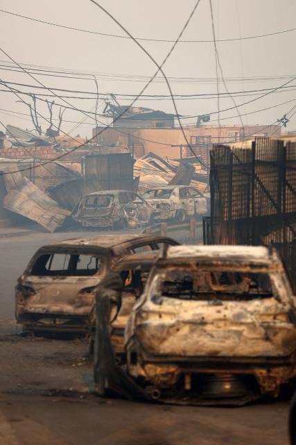 View of the remains of burned vehicles after a wildfire in Concepcion, Chile, on January 18, 2026. Chilean President Gabriel Boric declared a state of emergency on January 18 for two southern regions where raging wildfires have forced about 20,000 people to evacuate their homes. (Photo by Raul BRAVO / AFP)