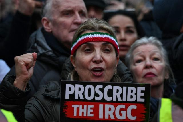Protesters hold placards as they take part in a march to Downing Street against Iran's crackdown on protesters, in London on January 18, 2026. (Photo by JUSTIN TALLIS / AFP)