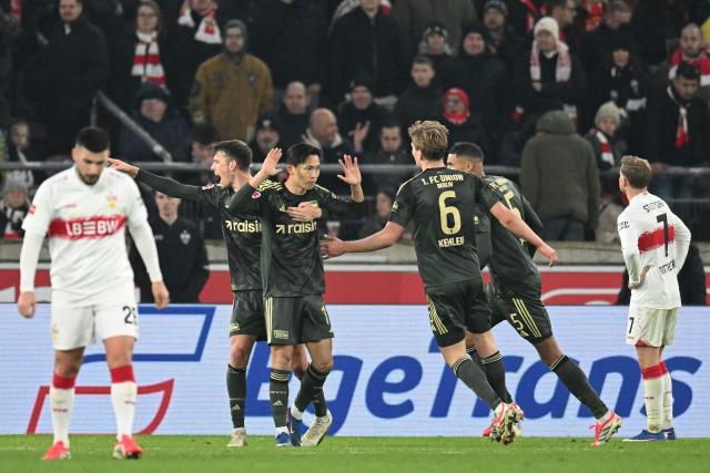 Union Berlin's South Korean midfielder #11 Jeong Woo-yeong (C) reacts with his teammates after scoring the 1-1 goal during the German first division Bundesliga football match between VfB Stuttgart and Union Berlin in Stuttgart, southern Germany, on January 18, 2026. (Photo by THOMAS KIENZLE / AFP) / DFL REGULATIONS PROHIBIT ANY USE OF PHOTOGRAPHS AS IMAGE SEQUENCES AND/OR QUASI-VIDEO