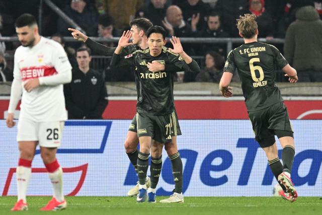 Union Berlin's South Korean midfielder #11 Jeong Woo-yeong (C) reacts with his teammates after scoring the 1-1 goal during the German first division Bundesliga football match between VfB Stuttgart and Union Berlin in Stuttgart, southern Germany, on January 18, 2026. (Photo by THOMAS KIENZLE / AFP) / DFL REGULATIONS PROHIBIT ANY USE OF PHOTOGRAPHS AS IMAGE SEQUENCES AND/OR QUASI-VIDEO