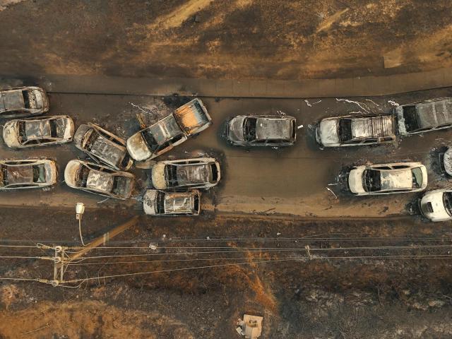 Aerial view of the remains of burned vehicles after a wildfire in Concepcion, Chile, on January 18, 2026. Chilean President Gabriel Boric declared a state of emergency on January 18 for two southern regions where raging wildfires have forced about 20,000 people to evacuate their homes. (Photo by Raul BRAVO / AFP)