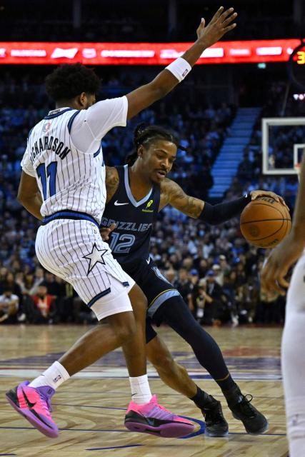 Memphis Grizzlies’ US point guard #12 Ja Morant (R) dribbles past Orlando Magic’s US shooting guard #11 Jase Richardson (L) during the 2025/2026 NBA season basketball match between the Memphis Grizzlies and Orlando Magic at the O2 Arena in London on January 18, 2026. (Photo by Glyn KIRK / AFP)