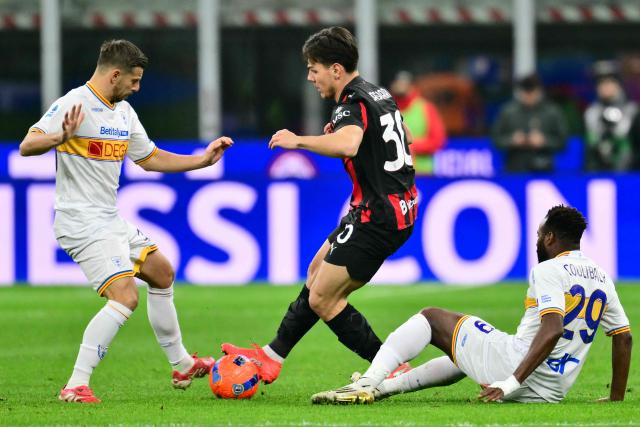 AC Milan's Swiss midfielder #30 Ardon Jashari fights for the ball with Lecce's Malian midfielder #29 Lassana Coulibaly and Lecce's Albanian midfielder #20 Ylber Ramadani during the Italian Serie A football match between AC Milan and Lecce at San Siro stadium in Milan, northern Italy, on January 18, 2026. (Photo by Stefano RELLANDINI / AFP)