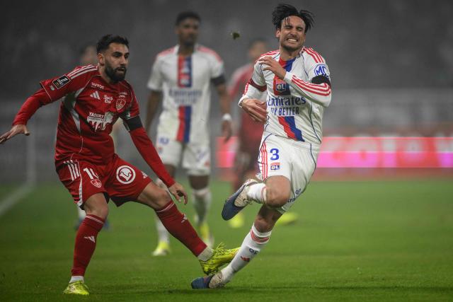 Brest's French forward #10 Romain Del Castillo (L) ) is sent off for making this tackle on Lyon's Argentine defender #03 Nicolas Tagliafico (R) during the French L1 football match between Olympique Lyonnais (OL) and Stade Brestois 29 at the Groupama Stadium in Decines-Charpieu, central-eastern France, on January 18, 2026. (Photo by OLIVIER CHASSIGNOLE / AFP)