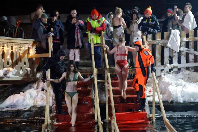 Orthodox believers plunge into the icy water on the eve of the Epiphany holiday in Izmaylovo, Moscow region on January 18, 2026. (Photo by TATYANA MAKEYEVA / AFP)