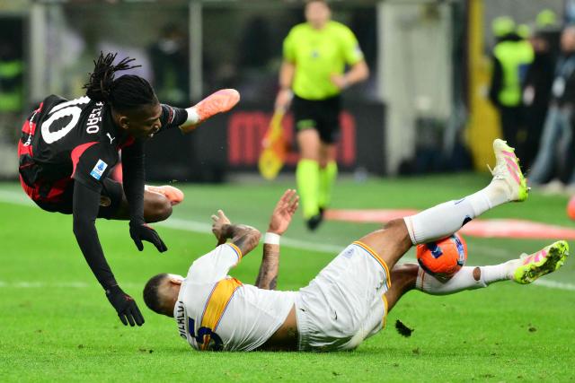 AC Milan's Portuguese forward #10 Rafael Leao is tackled by Lecce's German defender #05 Jamil Siebert during the Italian Serie A football match between AC Milan and Lecce at San Siro stadium in Milan, northern Italy, on January 18, 2026. (Photo by Stefano RELLANDINI / AFP)
