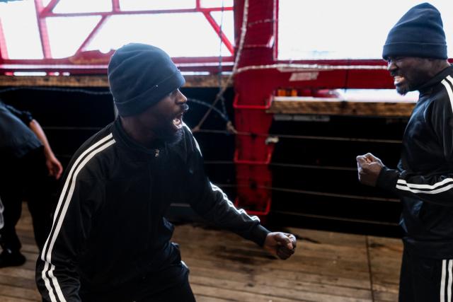 Migrants react as they play football onboard the rescue ship 'Ocean Viking' operated by the NGO SOS Mediterranee, as it sails in the Mediterranean Sea toward the designated port of disembarkation in Palermo, southern Italy, on January 18, 2026. (Photo by Sameer Al-DOUMY / AFP)