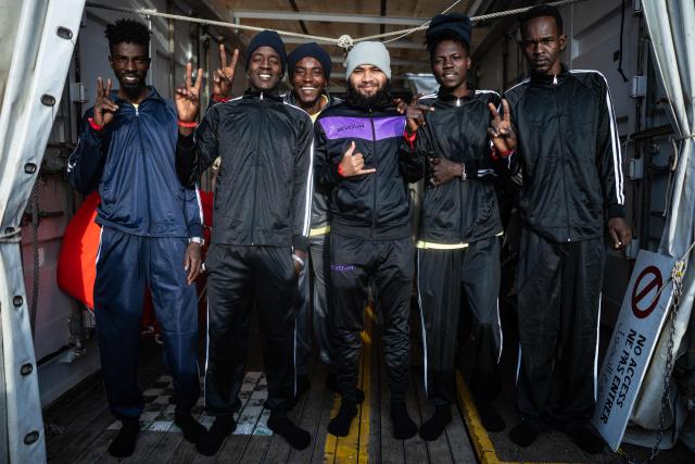 Migrants pose for a photograph onboard the rescue ship 'Ocean Viking' operated by the NGO SOS Mediterranee, as it sails in the Mediterranean Sea toward the designated port of disembarkation in Palermo, southern Italy, on January 18, 2026. (Photo by Sameer Al-DOUMY / AFP)