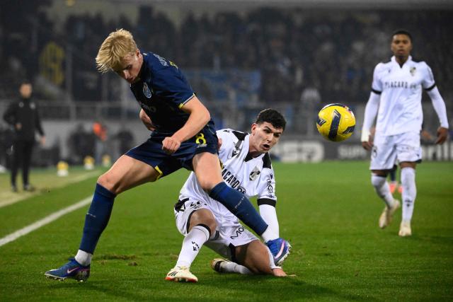 FC Porto's Danish midfielder #08 Victor Froholdt (L) and Vitoria Guimaraes's Portuguese midfielder # 30 Goncalo Nogueira fight for the ball during the Portuguese league football match between Vitoria Guimaraes SC and FC Porto at Dom Afonso Henriques stadium in Guimaraes on January 18, 2026. (Photo by Miguel RIOPA / AFP)